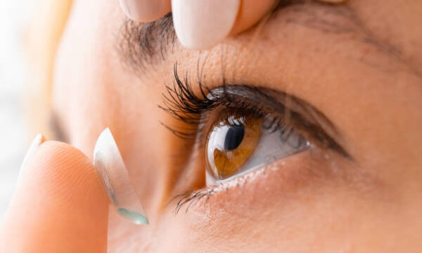 Close up woman applying contact eye lens